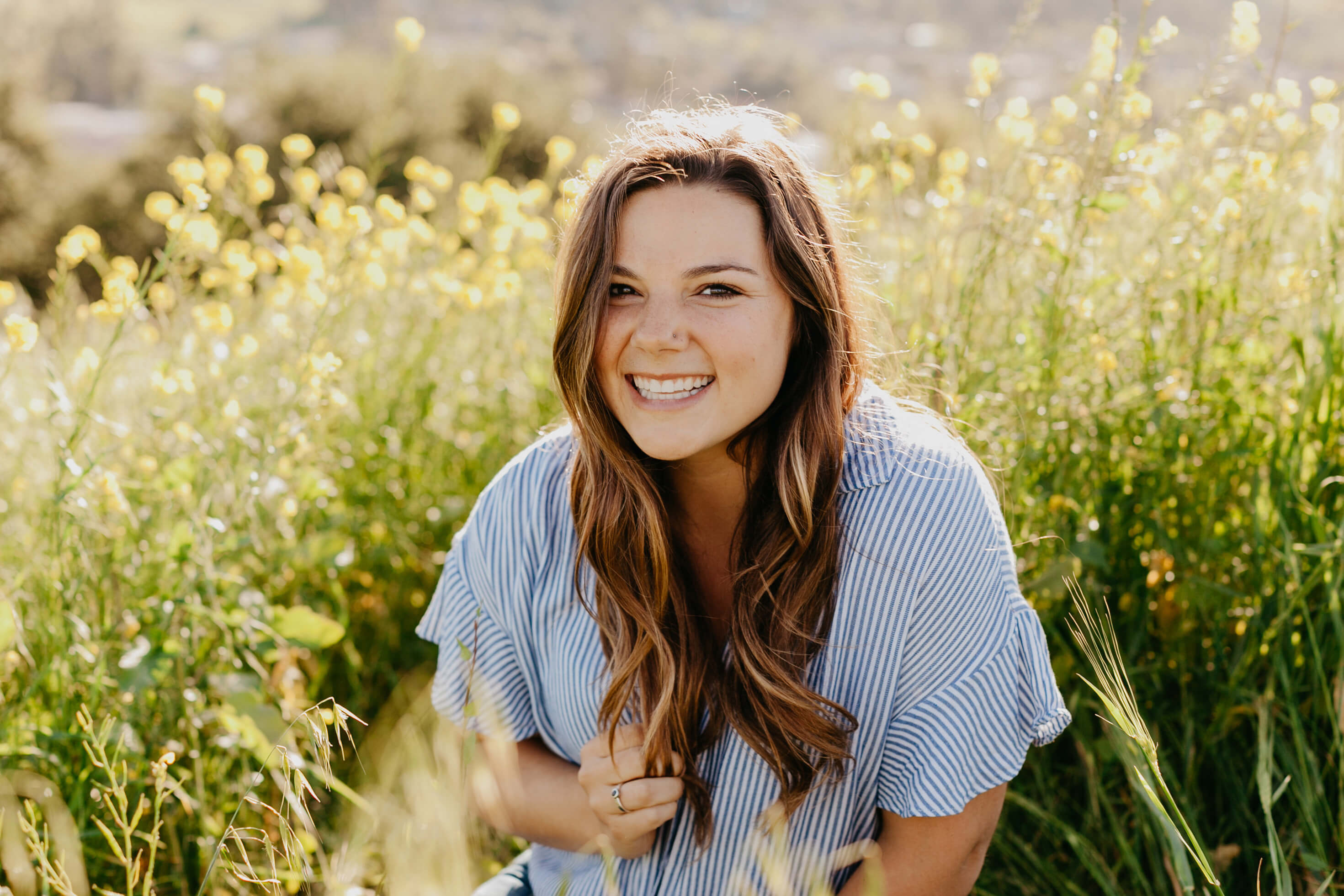 Student Grace Roman smiling while sitting in a grass field